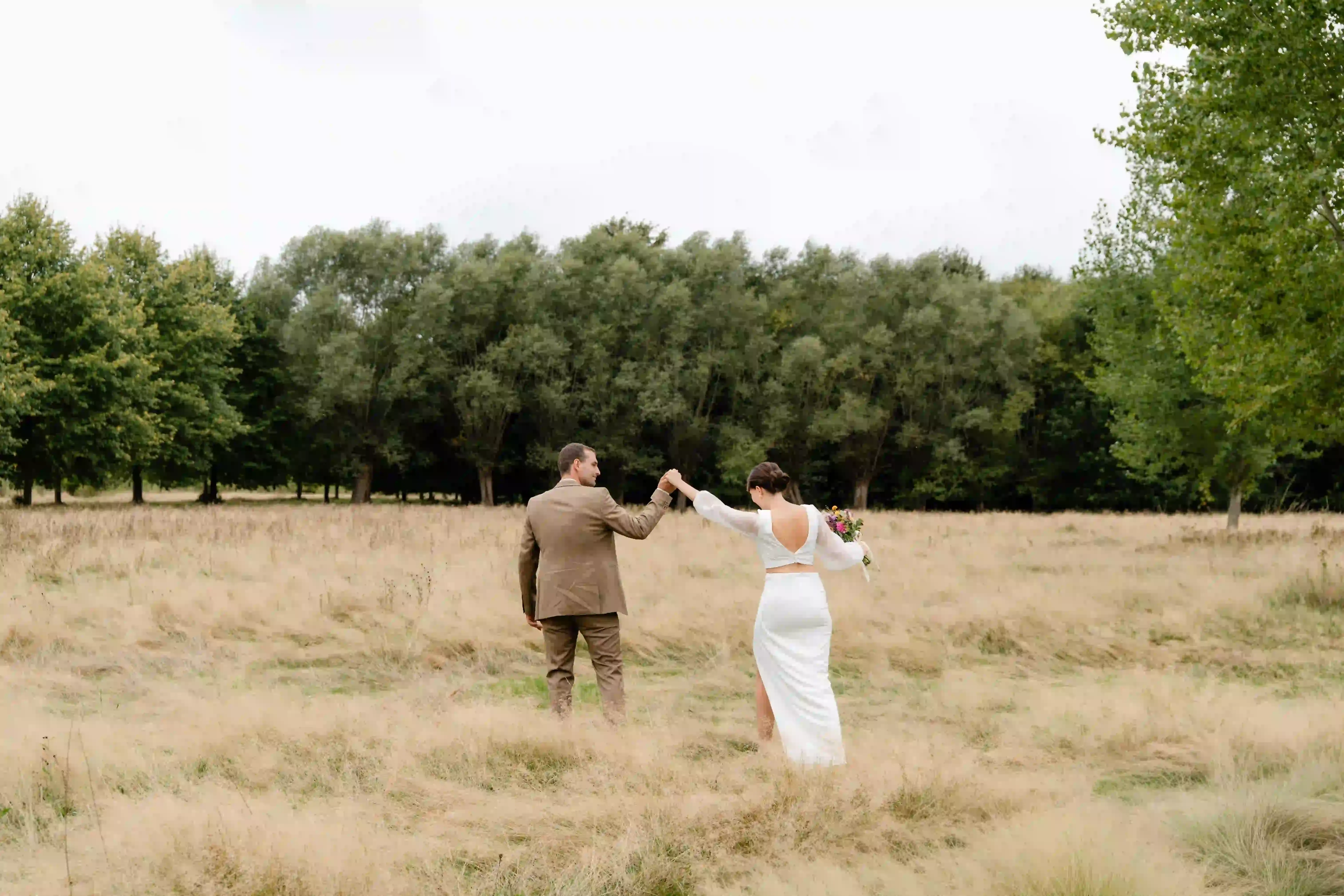 Wedding photography by Bert Van Den Eeckhaut — bride and groom dancing in field