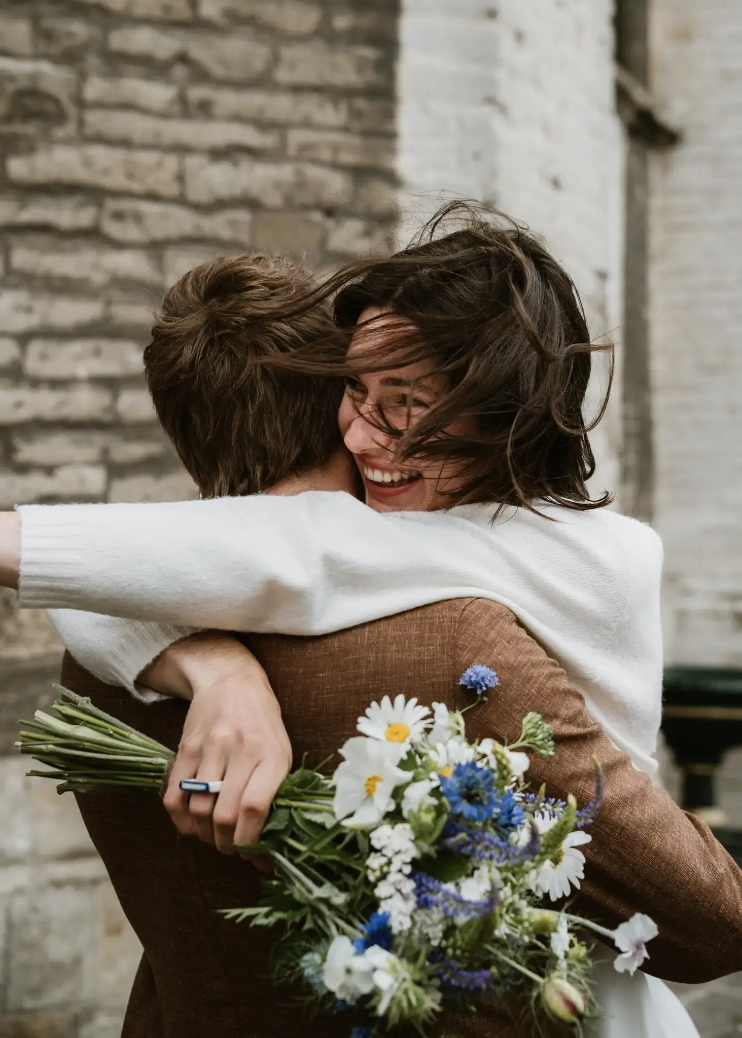 Wedding photography by Bert Van Den Eeckhaut — couple hugging outside building