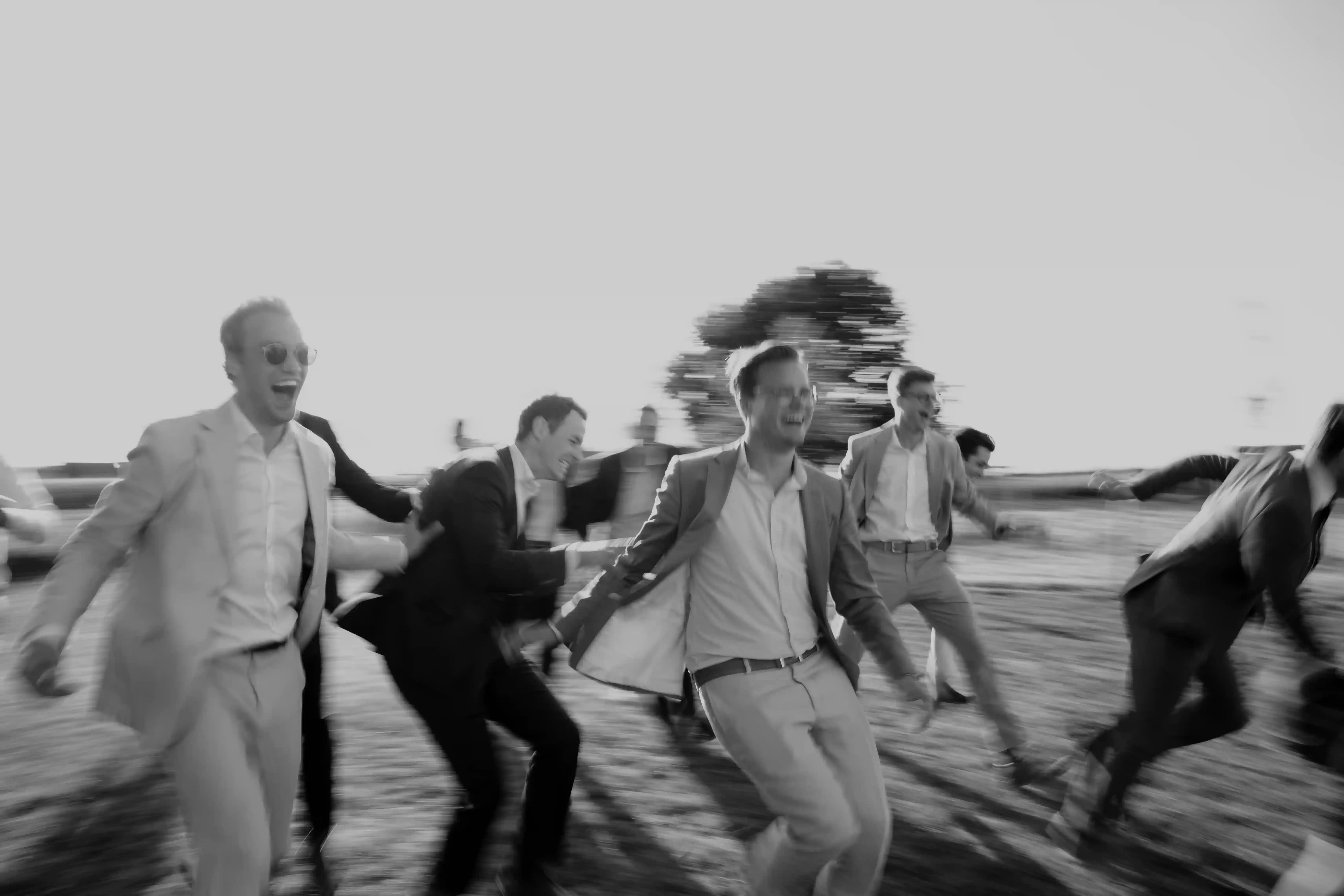 Wedding photography by Bert Van Den Eeckhaut — men running down sidewalk