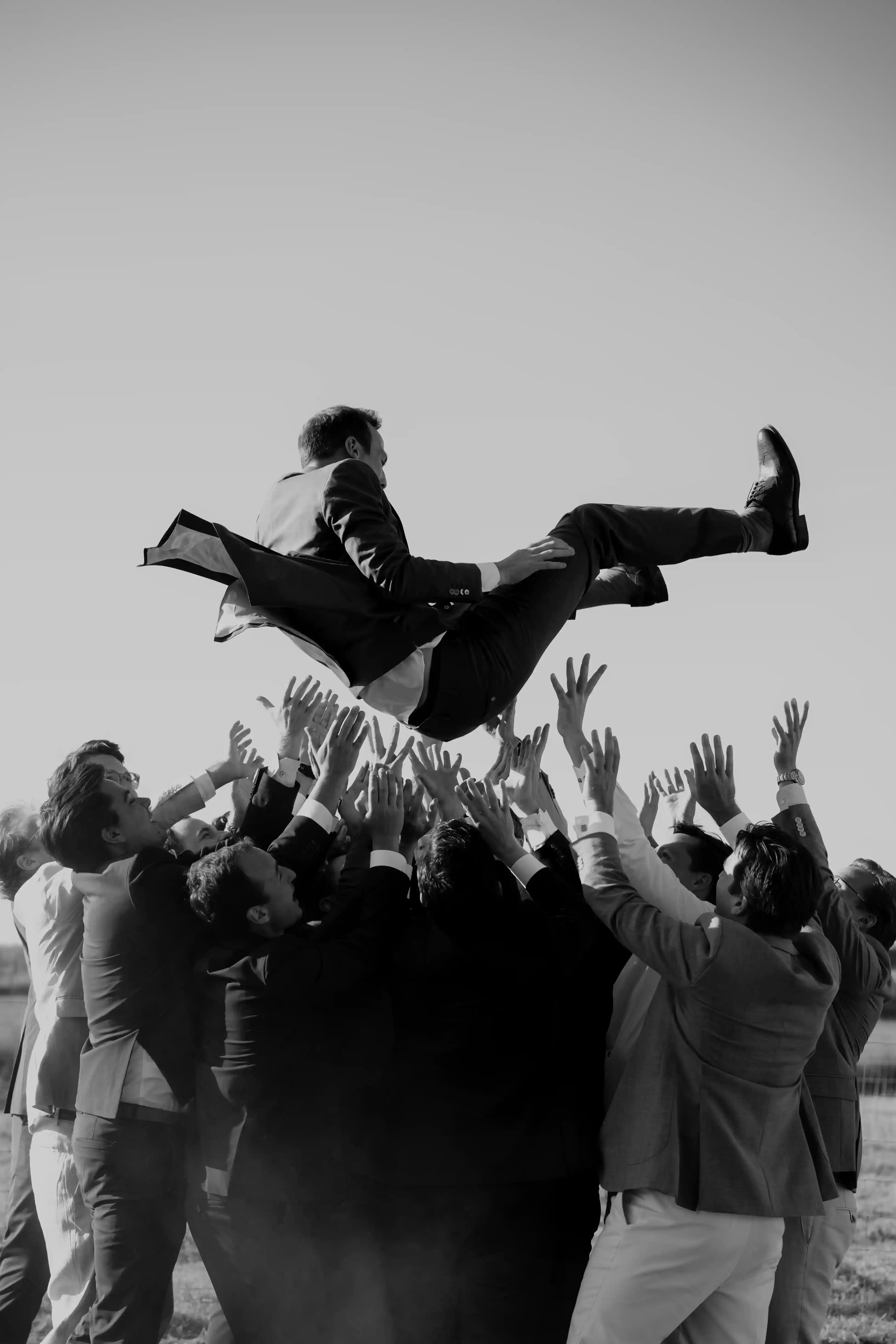 Wedding photography by Bert Van Den Eeckhaut — groom lifted up by guests