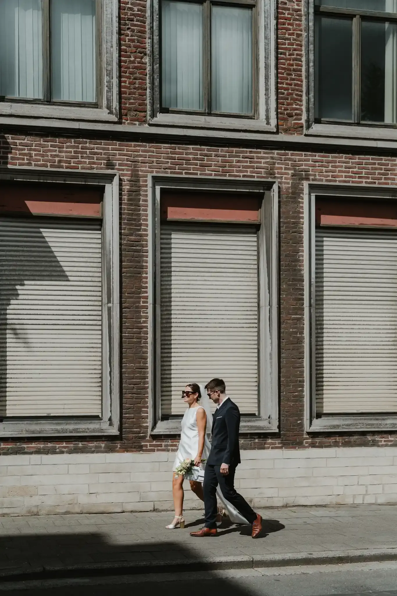 Wedding photography by Bert Van Den Eeckhaut — couple walking down street